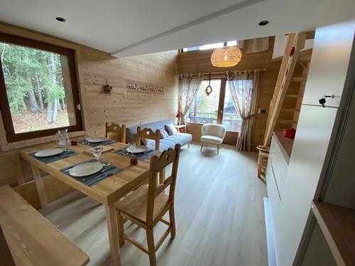 - une salle à manger et un salon avec une table dans l'établissement Duplex rénové avec balcon et garage à La Clusaz - FR-1-459-45, à La Clusaz