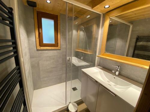 une salle de bain avec une douche, un lavabo et un miroir dans l'établissement Duplex rénové avec balcon et garage à La Clusaz - FR-1-459-45, à La Clusaz
