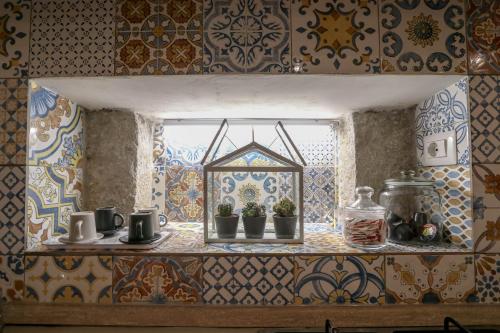 a kitchen window with potted plants on a shelf at Casanica-Taormina in Taormina