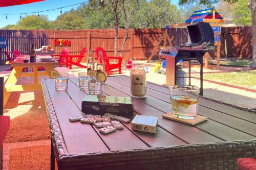 a picnic table in a backyard with a drink and a piano at San Antonio Family Home with Game Room and Fire Pit! in San Antonio