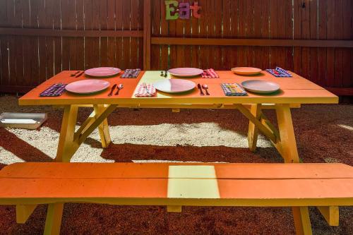 a picnic table with plates and utensils and a bench at San Antonio Family Home with Game Room and Fire Pit! in San Antonio