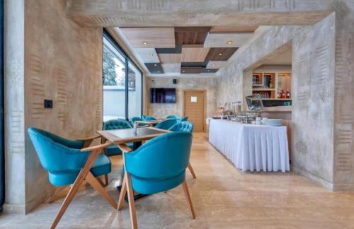 a dining room with blue chairs and a table at Zlatibor Apartman Aria Forest Spa & Gym in Zlatibor