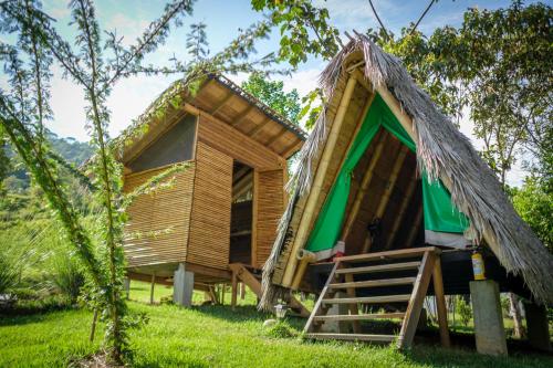 una casa en el árbol con techo de paja en La Perla Negra - Black Pearl Eco Hostel, en San Rafael