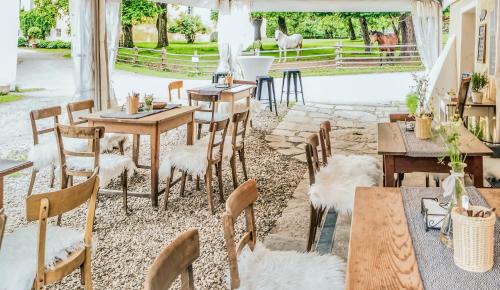 a restaurant with tables and chairs with a horse in the background at Unplugged Almhütte Waldbauer in Reichenfels