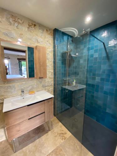 une salle de bain avec un lavabo et une douche dans l'établissement Maison de village, charme et confort, à Mauroux