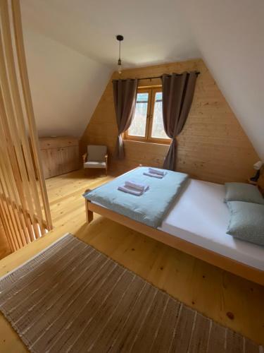 ein Schlafzimmer mit einem großen Bett im Dachgeschoss in der Unterkunft Apartman Lenka in Mokra Gora