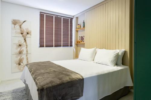 1 dormitorio con 1 cama con sábanas blancas y ventana en Apartamento com a cara de Maceió, en Maceió