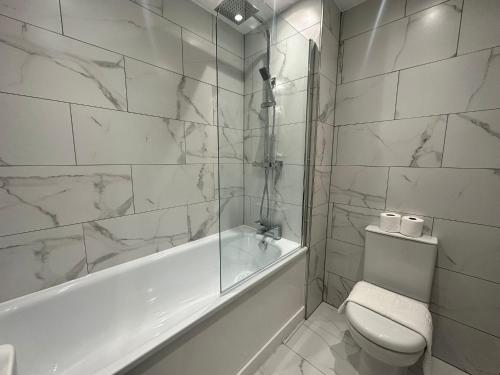 baño blanco con bañera y aseo en Kingsize Bed Luxury Hideaway Retreat by the Sea, en Brighton & Hove