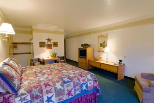 una camera d'albergo con letto e divano di Covered Wagon Motel Lusk WY a Lusk