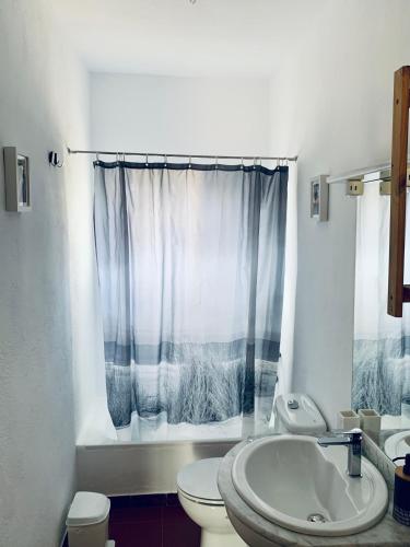 a white bathroom with a toilet and a sink at Casa rural Arroyo Marco in Guadalcanal