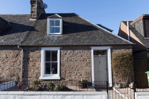 a brick house with a white door and windows at Clava Cottage City Centre in Inverness