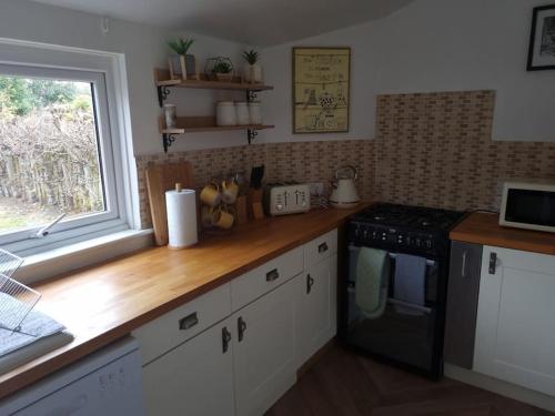 a kitchen with a black stove and a window at Clava Cottage City Centre in Inverness