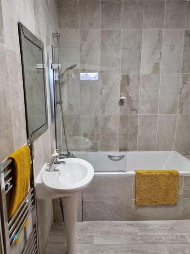 a bathroom with a sink and a shower and a bath tub at Clava Cottage City Centre in Inverness