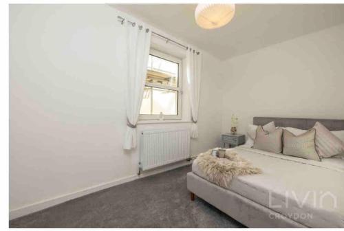 um quarto branco com uma cama e uma janela em Lovely 1 Bedroom Apartment em South Norwood