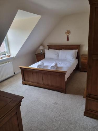 a bedroom with a large wooden bed with white sheets at Clava Cottage City Centre in Inverness
