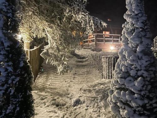 a snow covered path with a building in the background at Valkla Puhkekeskuse saunamaja in Kuusalu