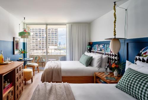 a hotel room with two beds and a window at Wayfinder Waikiki in Honolulu