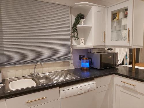 a kitchen with a sink and a microwave at White House in Chapeltown