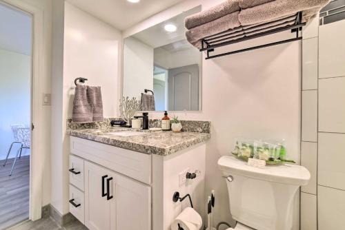 a bathroom with a sink and a toilet and a mirror at Modern and Cozy Condo Near Beaches with Coastal Views in Kahana