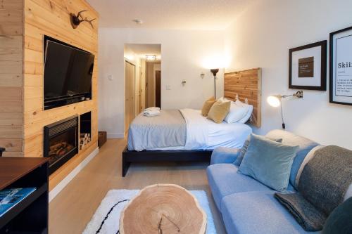 a bedroom with a bed and a couch and a tv at Impeccable Glacier Lodge Hotel Room w Pool+Hot Tub in Whistler
