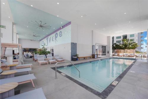 una gran piscina en un edificio con mesas y sillas en - Casiola Studio's - near Cruise Terminal, Bayfront Park and Kaseya Center, en Miami