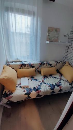 kanapę siedzącą w pokoju z oknem w obiekcie Studio apartman Bruna w mieście Ðakovo