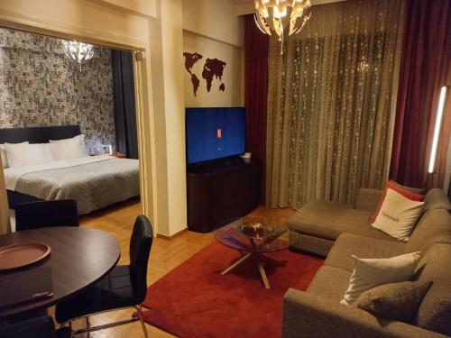 ein Hotelzimmer mit einem Bett und einem Wohnzimmer in der Unterkunft CityHome2 in Larisa