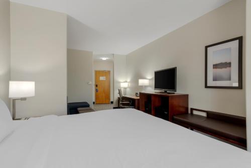 a hotel room with a bed and a flat screen tv at Comfort Suites Stockbridge Atlanta South in Stockbridge