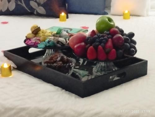 a tray of fruit on a table with candles at Pousada da Paz in Curitiba
