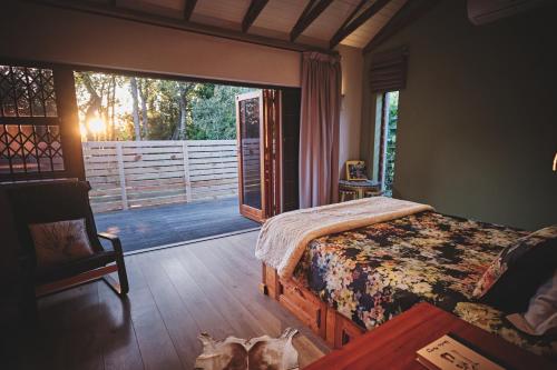 a bedroom with a bed and a door to a porch at The Cottage Farm in Stellenbosch