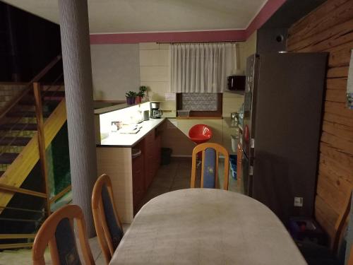 a small kitchen with a table and a refrigerator at Pokoje Gościnne Jaga in Kielce