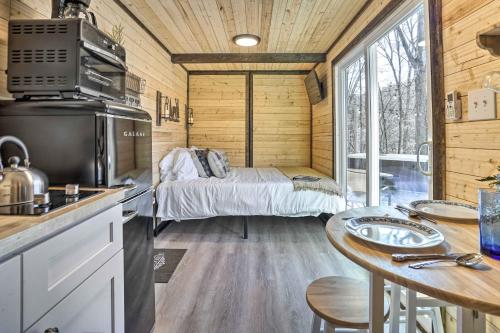 uma cozinha com uma cama e uma mesa numa pequena casa em Tiny Home with Hot Tub By Mohican State Park! em Loudonville