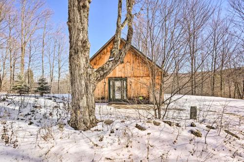 a log cabin in the snow with a tree at 8 Mi to Okemo Mtn Charming Ludlow Studio! in Ludlow