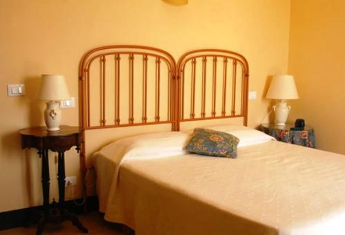 a bed in a bedroom with two tables and two lamps at Agriturismo Baglio Vecchio in Castelvetrano Selinunte