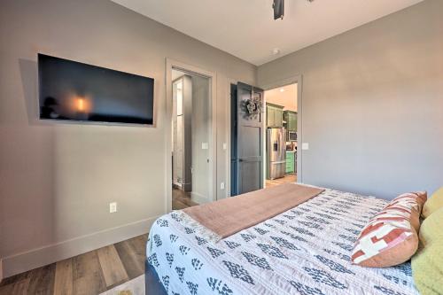 a bedroom with a bed and a flat screen tv at Lavish Riverfront Escape with Gas Grill! in Glenwood