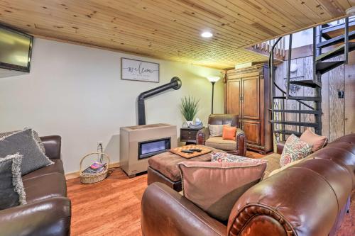 a living room with a leather couch and a fireplace at Fire Pit and Grill Woodside Nest in Pocono Lake! in Pocono Lake