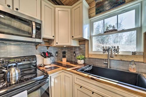a kitchen with a sink and a stove at Modern Cabin with Fire Pit Less Than 3 Mi to Trails! in Pisgah Forest