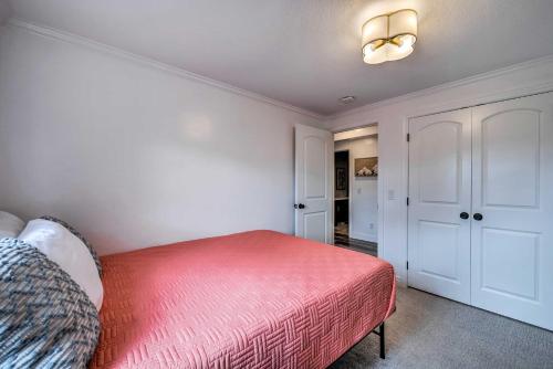 a bedroom with a bed with a red blanket at Spacious Layton Retreat with Private Hot Tub! in Layton