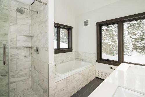 a white bathroom with a tub and a sink at 360 Chalet in Big Sky