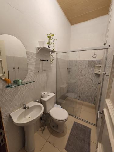 a bathroom with a toilet and a sink and a shower at Vila Shangri-la Algodoal- Suítes e Redário in Algodoal