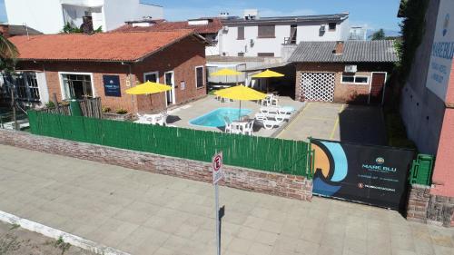 an overhead view of a swimming pool with yellow umbrellas at Mare Blu - Pousada Hostel in Torres