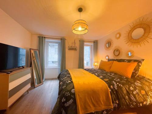 a bedroom with a bed and a flat screen tv at Maison centre Les Pieux*Wifi*OXO in Les Pieux