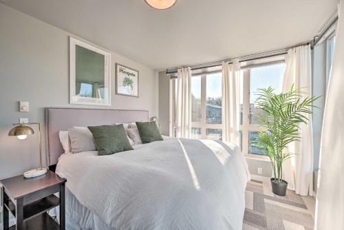 ein Schlafzimmer mit einem weißen Bett und einem großen Fenster in der Unterkunft Sleek Seattle Home with Rooftop Patio and Views! in Seattle