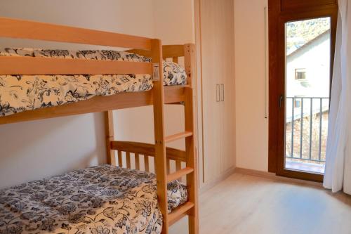 埃斯特里達內烏的住宿－Apartament comfortable amb vistes i cèntric by RURAL D'ÀNEU，一间卧室设有两张双层床和一扇窗户。
