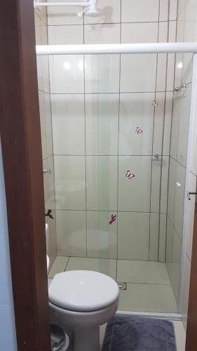 a bathroom with a toilet and a shower at Hospedagem 20m da praia. in Itapema