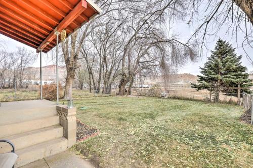 a house with a porch and a yard with trees at Cozy Helper Home with Fenced Yard, Pets Welcome in Helper