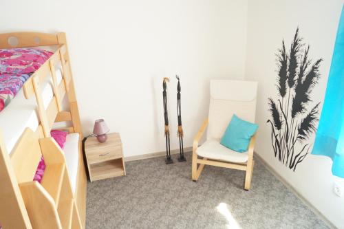 a doll house bedroom with a bunk bed and a chair at Ferienwohnungen Denk in Niederalteich