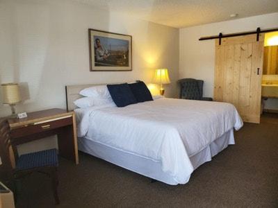 a hotel room with a bed and a desk and a bed sidx sidx sidx at Old Montana Inn in Deer Lodge