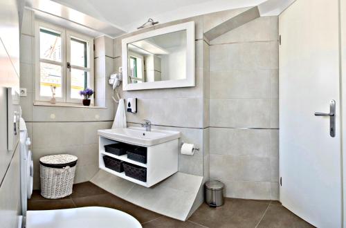 ein Bad mit einem Waschbecken und einem Spiegel in der Unterkunft Villa Daky in Split