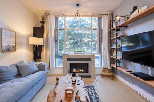 a living room with a couch and a fireplace at Bright Suite at Ski In/Out Glacier Lodge! in Whistler